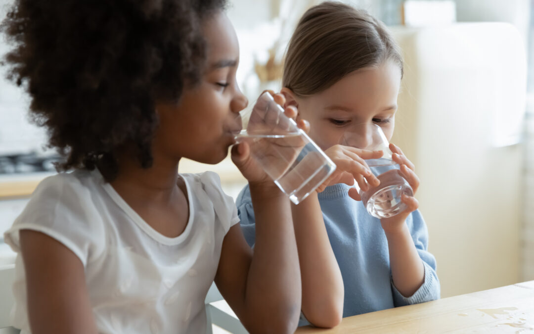 young kids drinking a glass of water